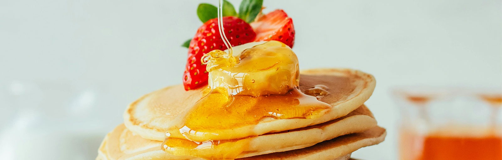 Pankakes de avena integral con frutilla y plátano, bañados con miel de abejas.